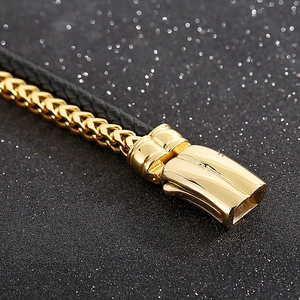 Macro shot of men's braided leather bracelet with golden chain and magnetic clasp