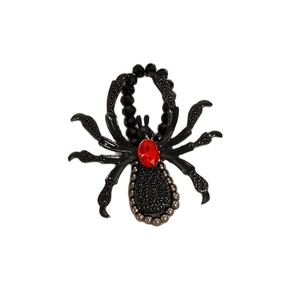 Close-up of Gothic black spider brooch with a ruby red gemstone and beaded texture