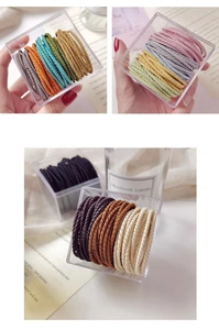 Detailed view of high-elastic braided hair ties with striped texture in a clear box