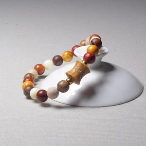Macro shot of Buddhist wooden prayer beads with various materials and carved charms