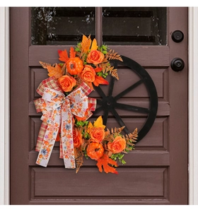 Detail of harvest wreath with orange roses, mini pumpkins, and a black wheel base