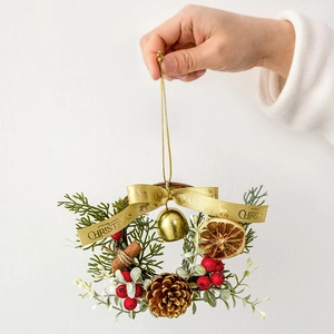 Mini Christmas wreath with pine cones, red berries and a golden bell hanging ornament