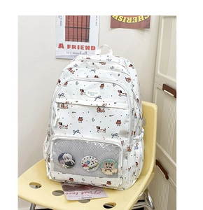 Detailed view of white canvas backpack featuring a transparent mesh pocket and dog print