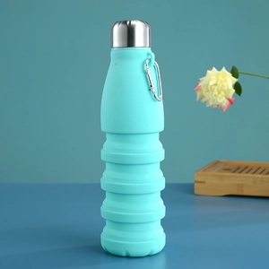 Gros plan sur la gourde pliable en silicone bleu ciel avec mousqueton en métal sur surface