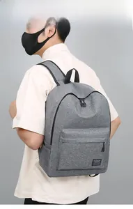 Detail of grey oxford travel backpack showing large front pocket and side bottle holder