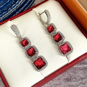 Macro shot of square red zircon drop earrings with pave diamonds in a luxury gift box