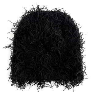 Close-up of black knitted beanie featuring long fringe and shaggy texture details