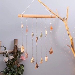 Bohemian crystal suncatcher with natural stones on a wooden bar for wall decoration