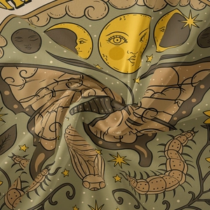 Detail of bohemian tapestry featuring moths, stars, and moon on green fabric texture