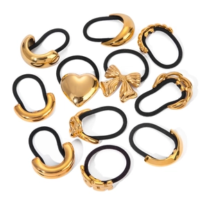 Flat lay of 11-piece set featuring gold heart and moon metal charms on black hair ties