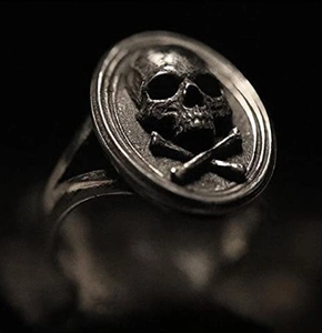 Macro detail of gothic skull and crossbones relief on retro silver punk ring band