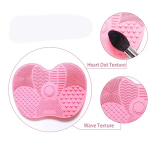 Pink silicone makeup brush cleaning mat with suction cups and various washing textures