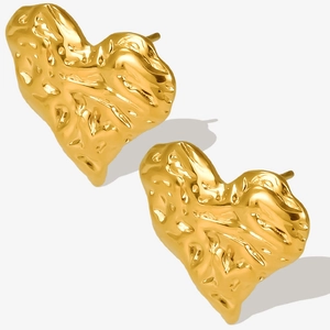 Macro detail of golden heart studs featuring unique lava-like textured metal surface