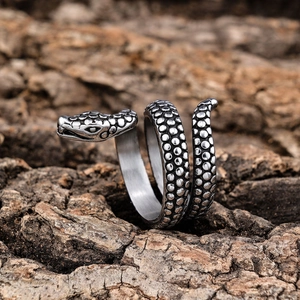 Macro shot of a punk snake ring with detailed silver scales on a rustic wood background
