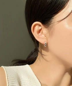 Detail view of 925 sterling silver hoop earrings with star patterns and small zircons