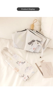 Detail of cute cat pattern folding umbrella with matching tote bag and wooden handle