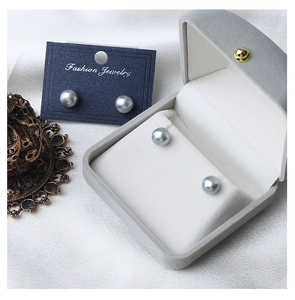 Macro shot of dark grey natural freshwater pearl earrings on silk fabric and velvet box