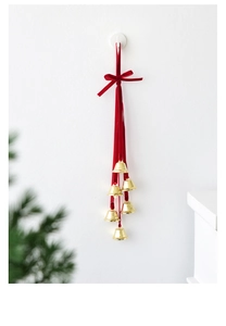 Detail of festive red velvet ribbon bow with six golden metal bells for Christmas decor