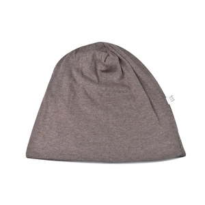 Detailed view of dark brown knitted beanie showing soft acrylic fabric and care label