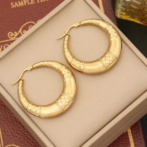 Close-up of golden bamboo texture hoop earrings in a premium jewelry box