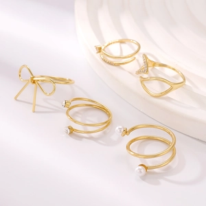Detailansicht eines 5-teiligen goldenen Schleifen-Ring-Sets mit Perlen und Zirkonia