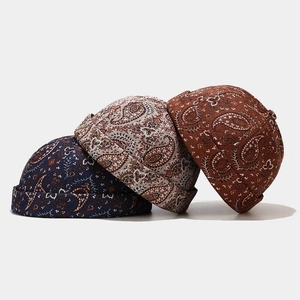 Vue détaillée des bonnets docker à motif paisley en bleu marine, beige et marron foncé