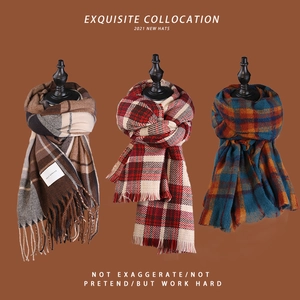 Close-up of winter plaid scarves with soft fringes in brown, red, and blue patterns
