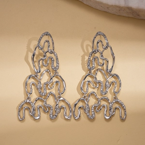 Macro detail showing silver irregular wavy geometric drop earrings with sparkling crystals