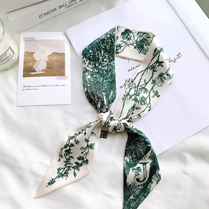 Close-up of floral silk scarf with letter J print on elegant white fabric background