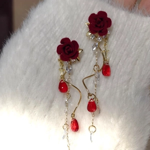 Macro shot of vintage velvet rose earrings with crystal tassels and red teardrop beads