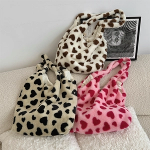 Detailed plush texture of three heart-patterned faux fur tote bags in varied winter colors