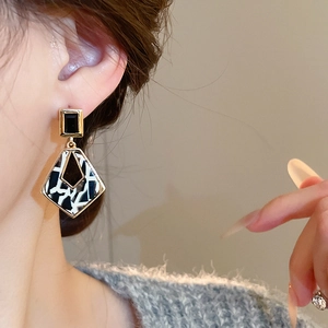 Gros plan de boucles d'oreilles géométriques léopard portées par un mannequin femme