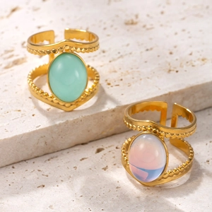 Detail view of gold rings with oval green and pink natural stones in a vintage double-line style