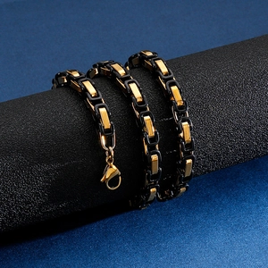 Macro shot of men's two-tone black and gold link chain necklace with lobster clasp
