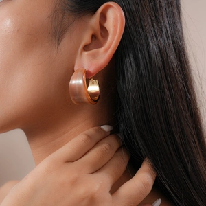 Close-up of retro resin C-shaped hoop earring in brown stripe pattern with gold metal clasp