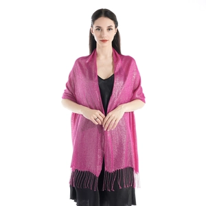 Detailed view of pink sparkling shawl with fringe tassels on elegant model shoulders