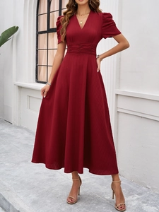 Detail of elegant V-neck dark red dress featuring puff sleeves and textured fabric