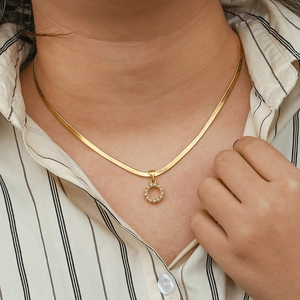 Close-up of 18K gold-plated flat snake chain with pearl pendant on a model