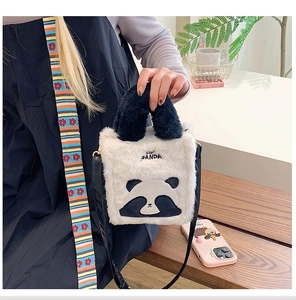 Detail of cute plush panda shoulder bag with adjustable strap and embroidered panda text