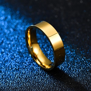 Nahaufnahme des 6mm polierten Gold-Titanstahlrings mit elegantem Bokeh-Hintergrund