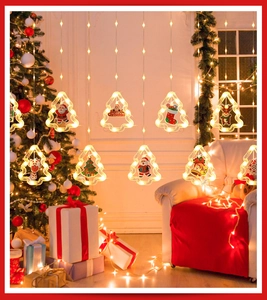 Detail of warm white Christmas window curtain lights with Santa and reindeer hanging ornaments