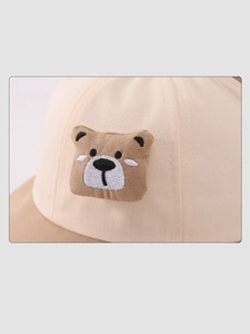 Close-up of beige cotton bucket hat with detailed 3D embroidered bear patch for kids