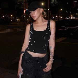 Close-up of silver studs on a black knit crop top with trendy street style Y2K details