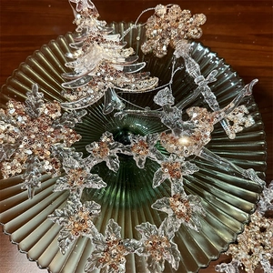 Champagne gold glitter snowflake and ballet girl ornaments on dark green tray