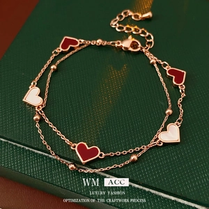 Bracelet double couche en or rose avec pendentifs cœurs en nacre rouge et blanche