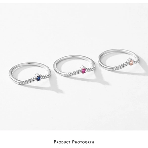 Close-up of S925 sterling silver rings with colorful zircon stones in blue pink and peach