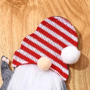 Close-up detail of knitted gnome Christmas cutlery holder with white faux fur beard