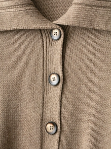Close-up of tan knit cardigan showing rib-knit texture and vintage tortoise buttons