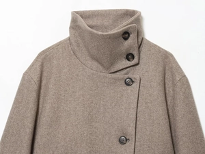 Détail du col montant et des boutons sur ce manteau en laine camel pour femme