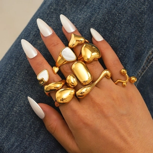Stackable gold asymmetric geometric rings with heart and shell inlay on denim fabric